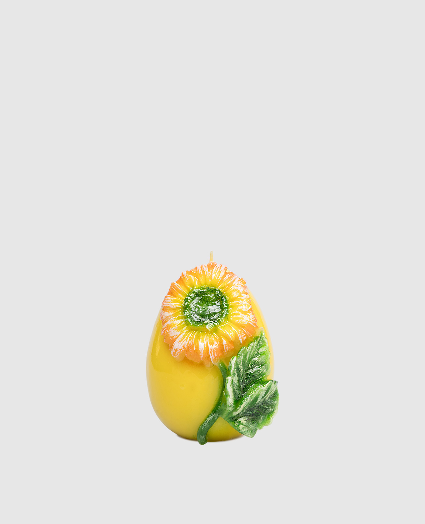 Желтая свеча в форме яйца с герберой